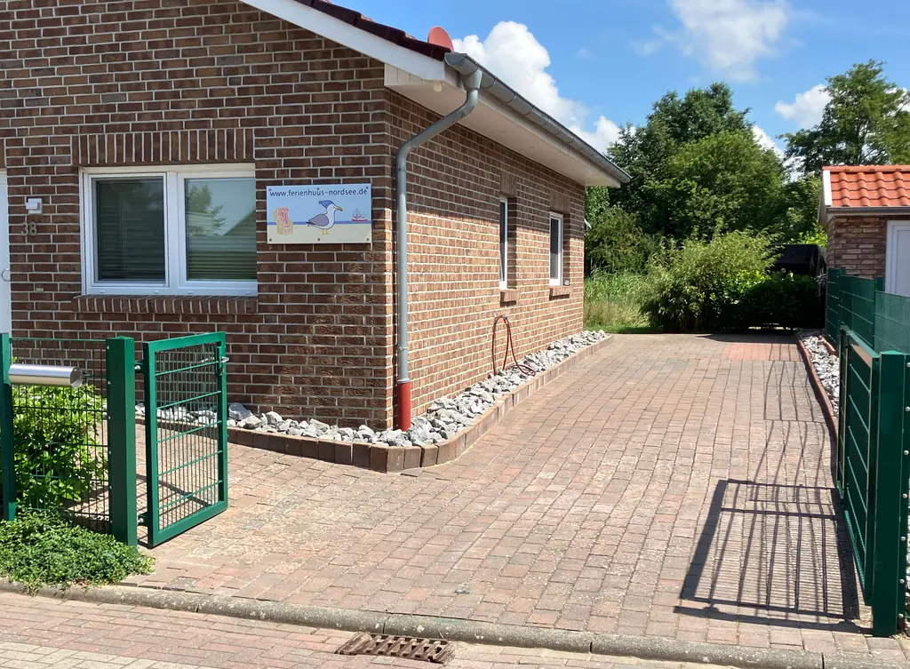 Haus mit Gartentor und gepflastertem Weg