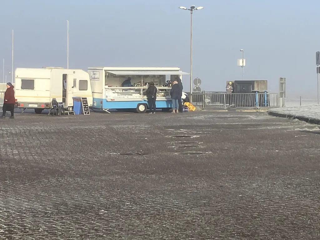 Parkplatz mit Imbisswagen am Kutterhafen im Nebel