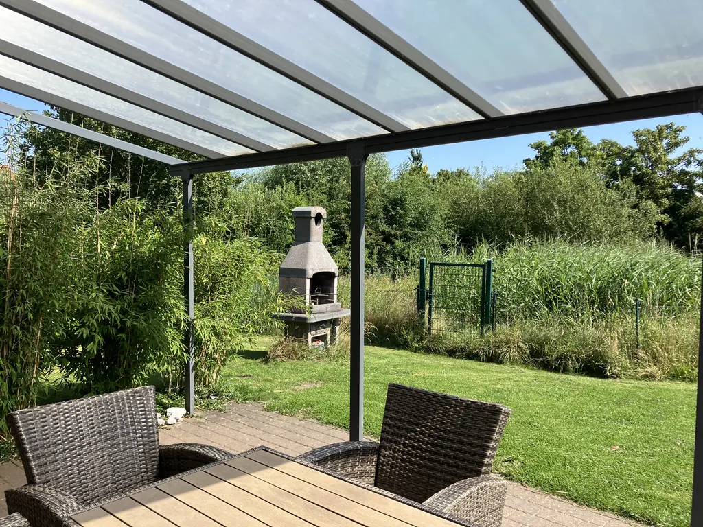 Überdachte Terrasse mit Sitzgruppe im Garten
