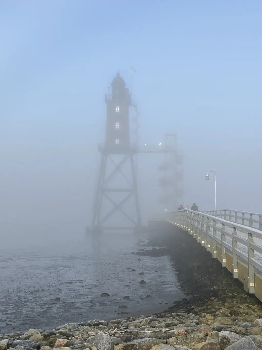 Leuchtturm am Steg im Nebel