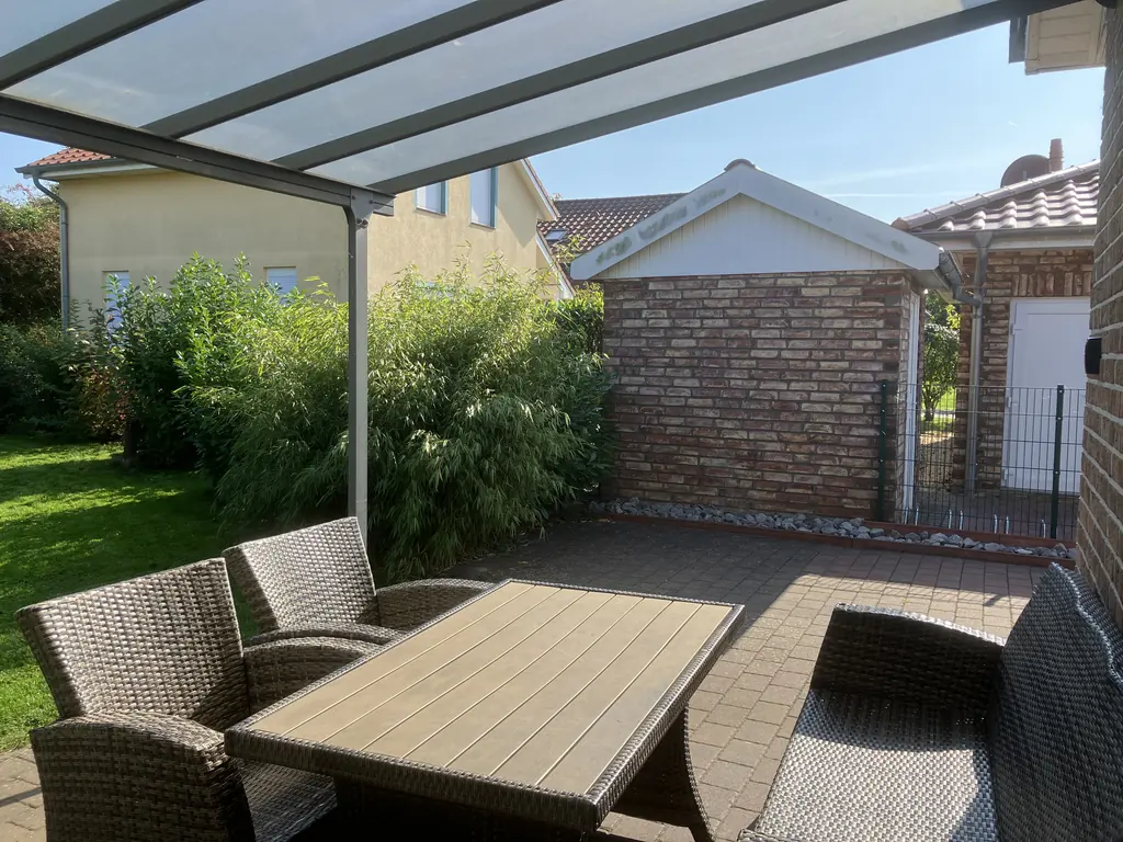 Überdachte Terrasse mit Gartenmöbeln