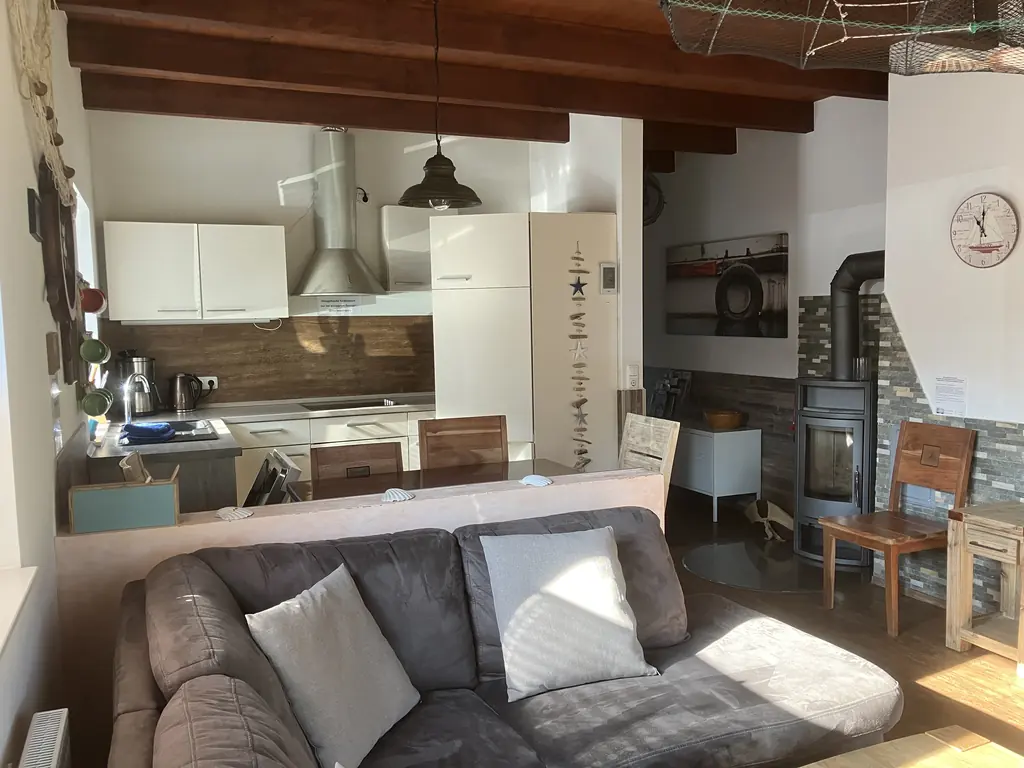 Wohnbereich mit Sofa und Küche im Hintergrund