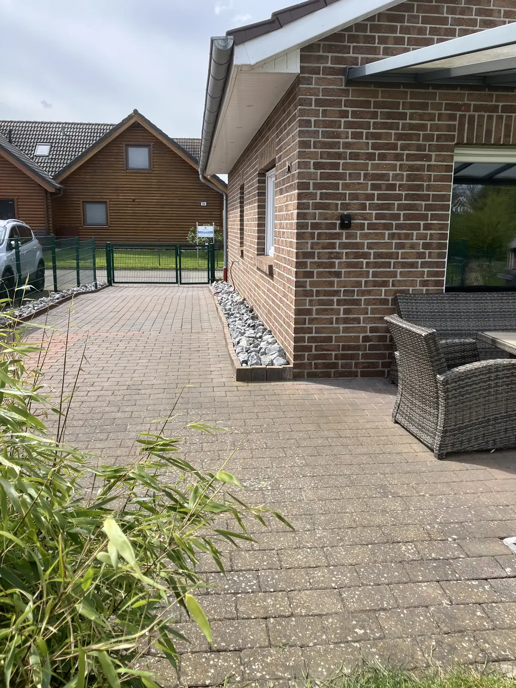 Gepflasterter Weg zwischen Haus und Garten